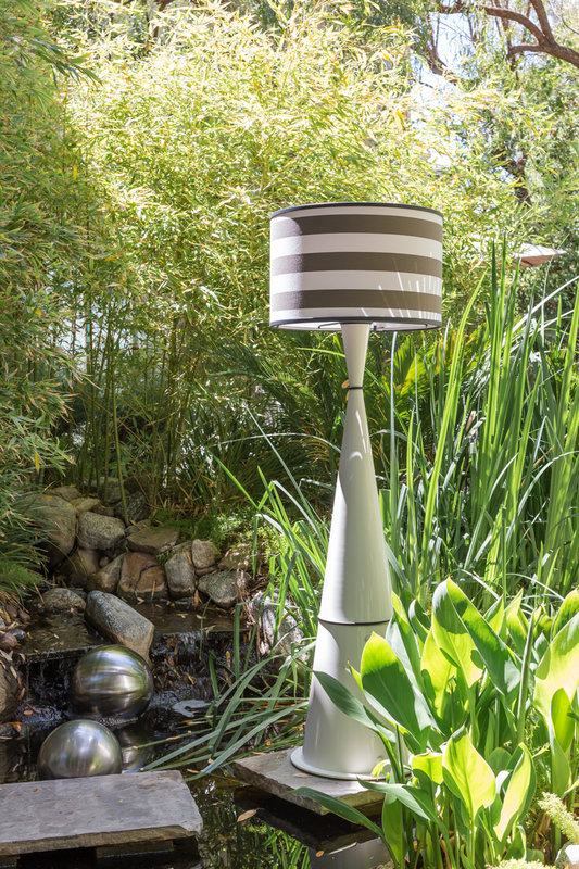 Live. Anywhere. floor lamp shown in lush outdoor setting