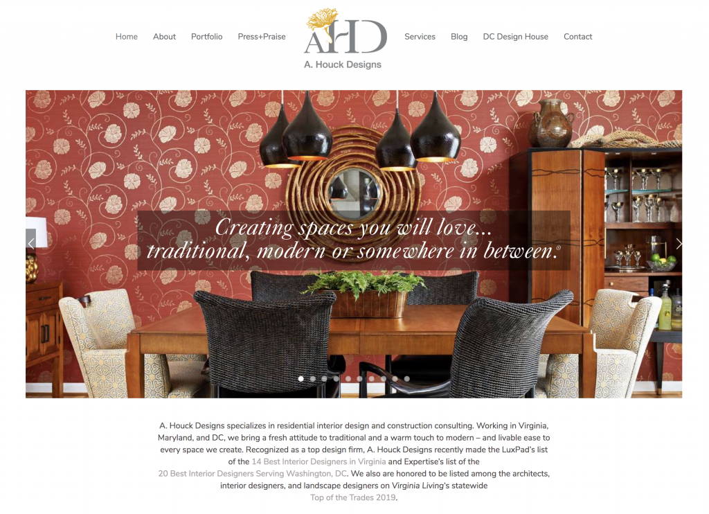 Homepage of new A. Houck Designs website featuring dining room with red wallpaper