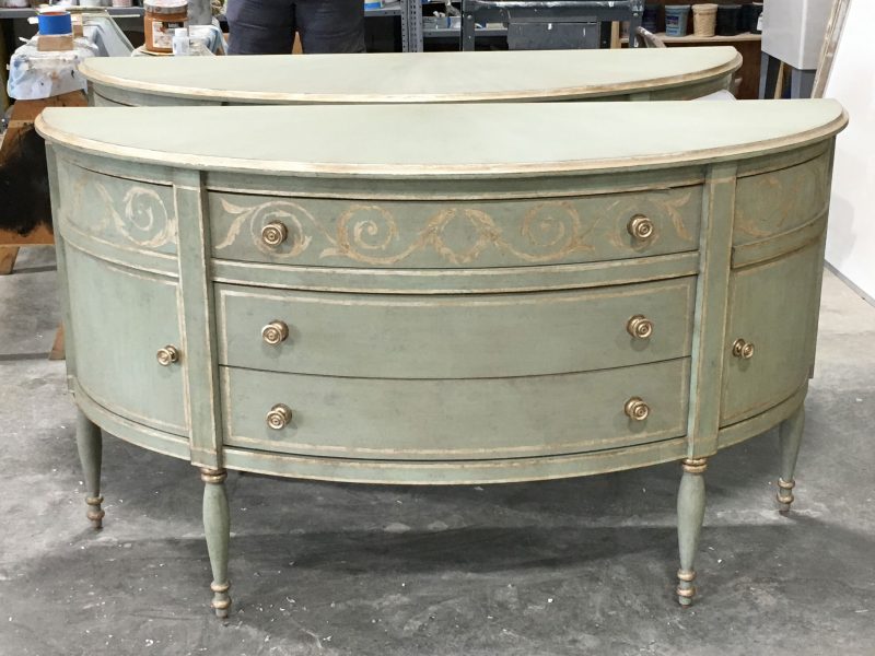 Demi-lune console with painted, blue-green finish on studio floor