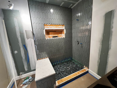 bathroom renovation in progress with new shower bench and picket shower wall tile
