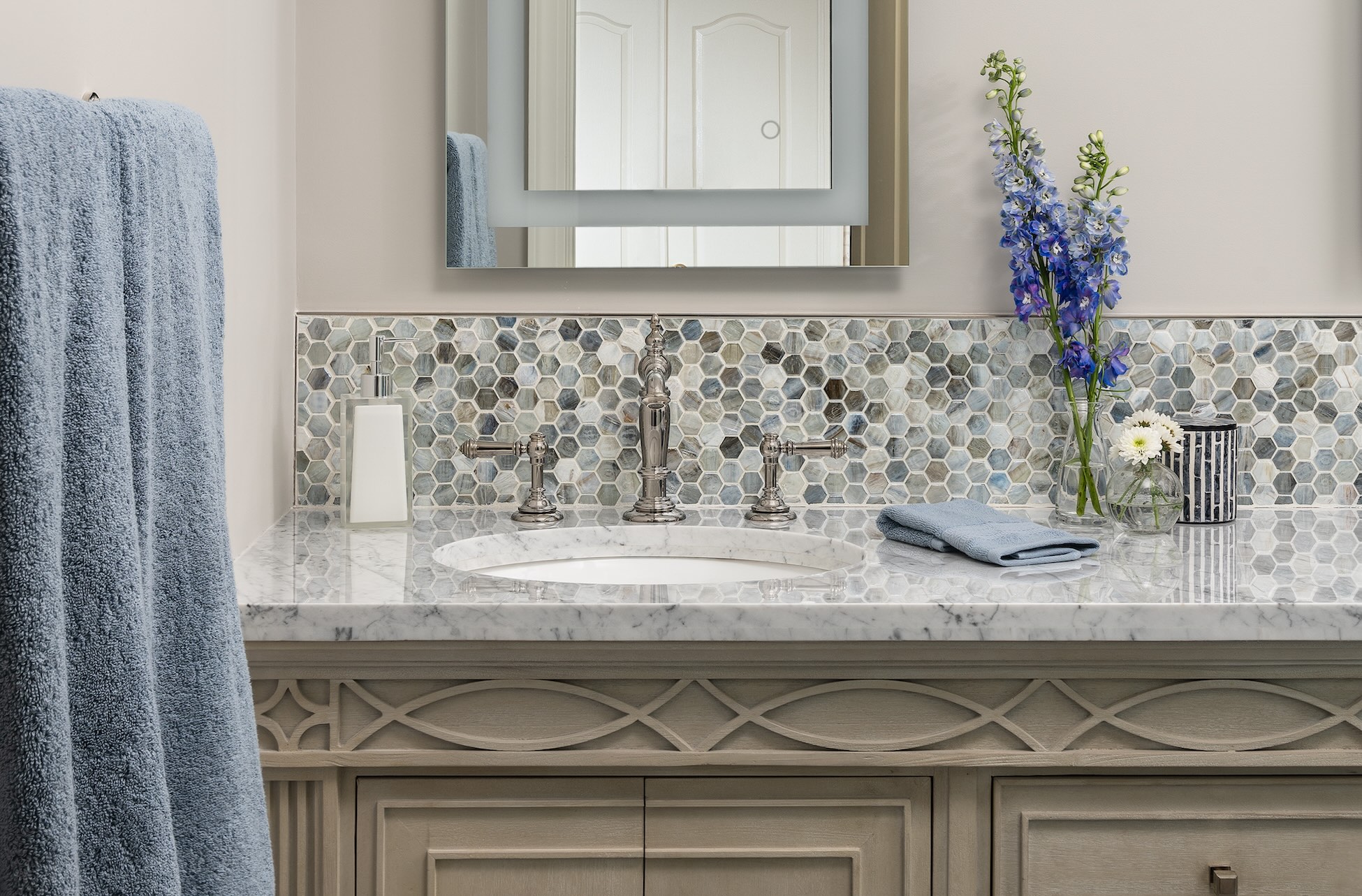 Painted, updated-traditional bathroom vanity with marble countertop, hexagon mosaic backsplash, nickel faucet, lighted vanity mirror