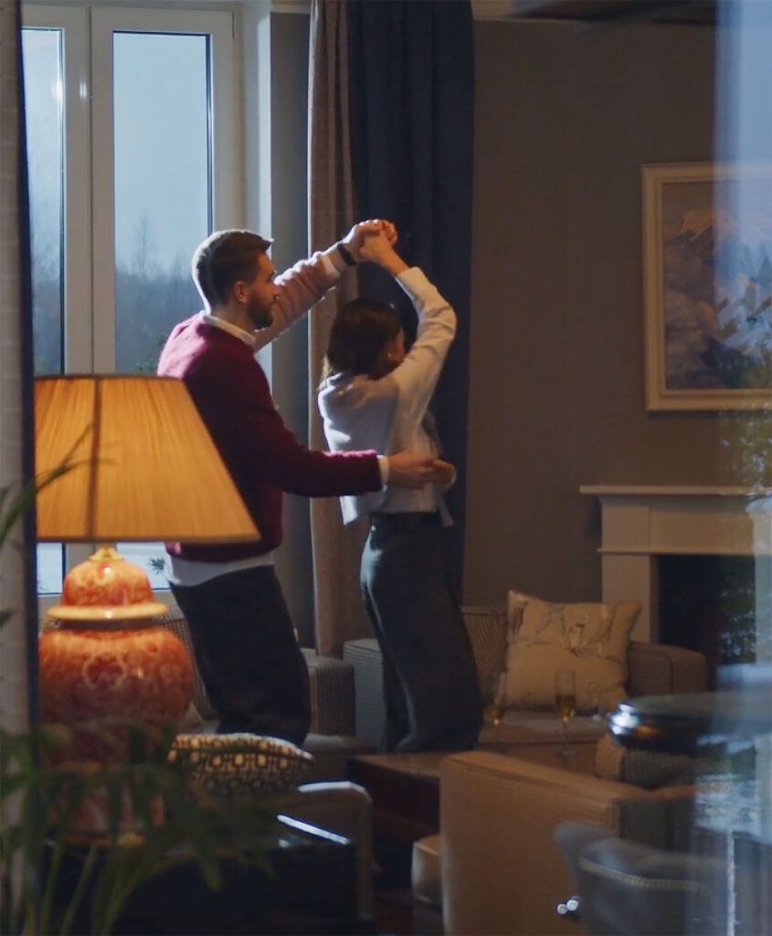 Couple dancing in a cozy living room.