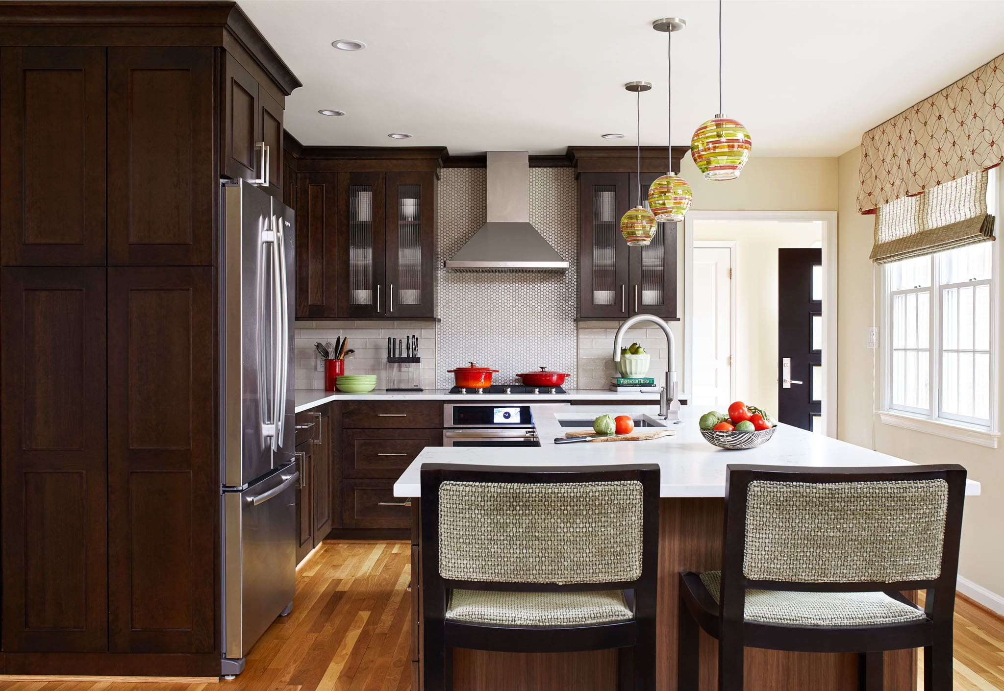Kitchen island with three glass pendant lights overhead.