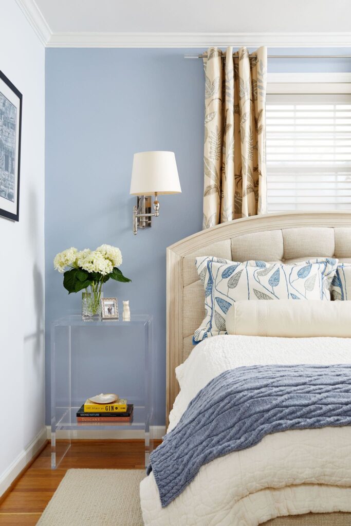 Primary bedroom with custom tufted headboard and blue walls.