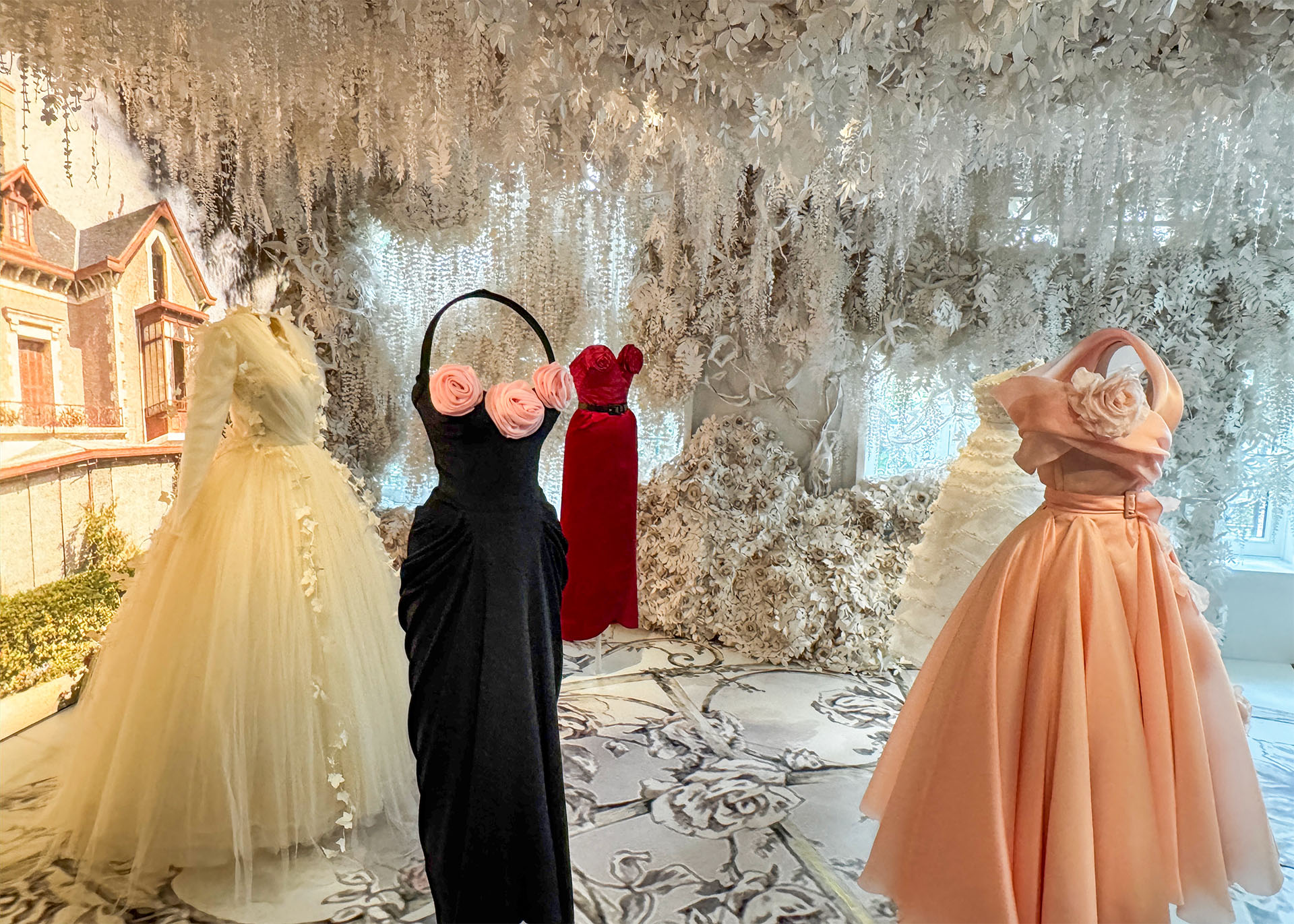 Elegant dresses on display in a floral-themed boutique setting, showcasing varying styles and colors.