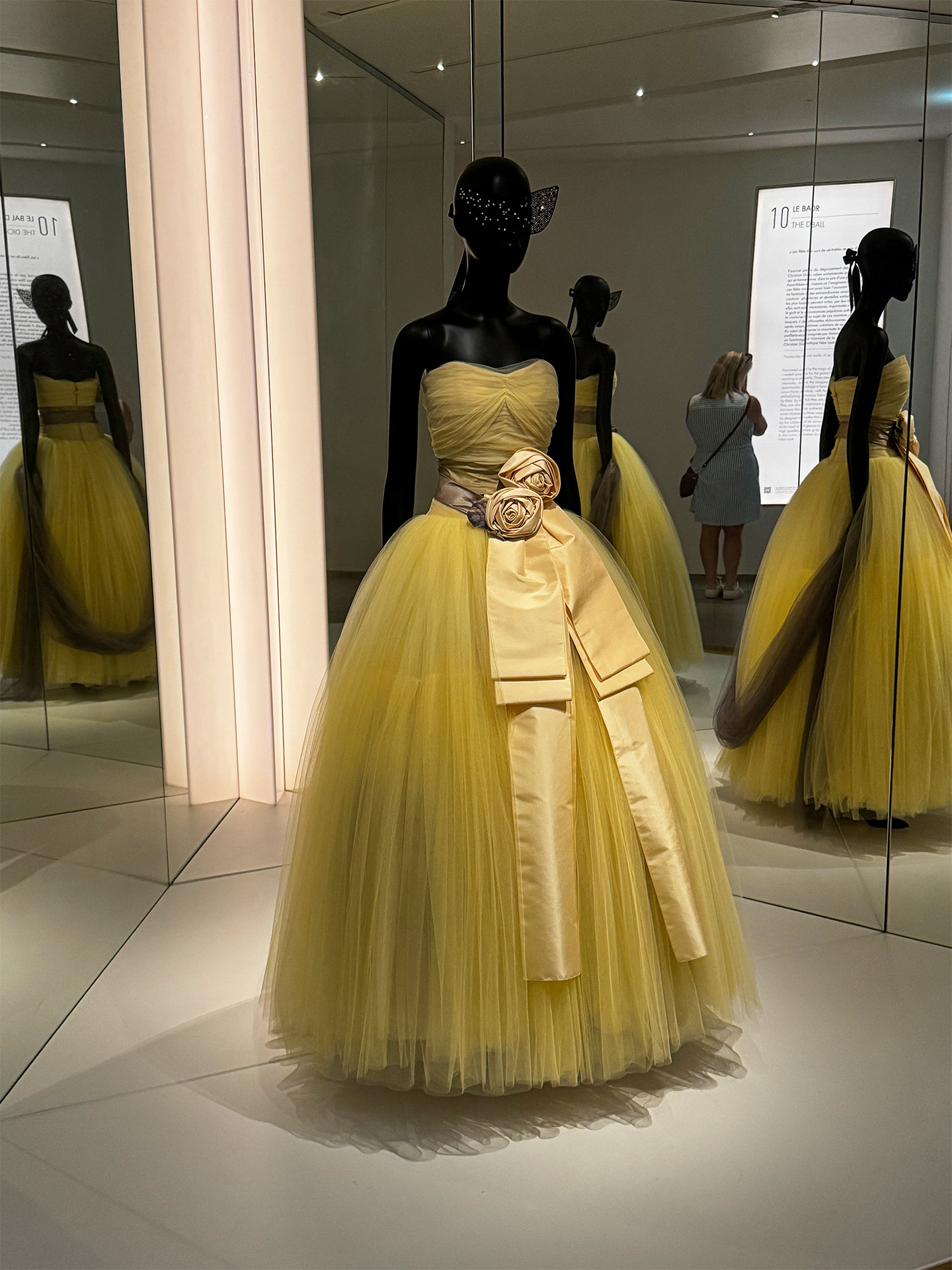 Elegant yellow ball gown displayed on a mannequin, featuring a fitted bodice and voluminous tulle skirt.