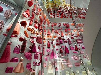 Colorful display of fashion accessories and dresses in a museum exhibit showcasing vibrant textiles and design elements.
