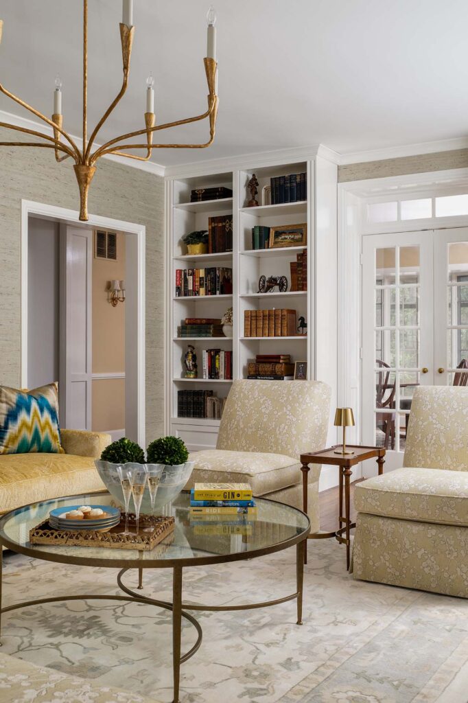 Elegant living room featuring a chandelier, cozy seating, and built-in bookshelves.